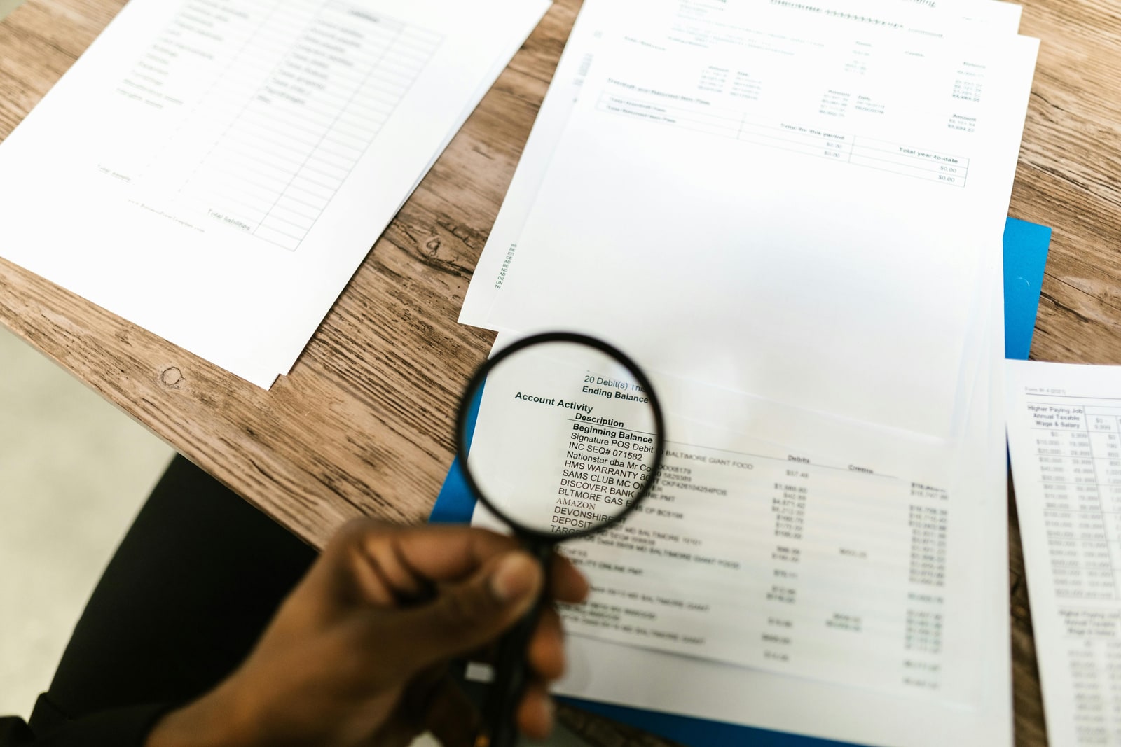 Property manager using a magnifying glass to review a rental application document